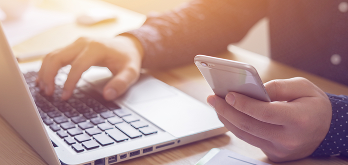 man holding mobile and working on laptop mobile banner